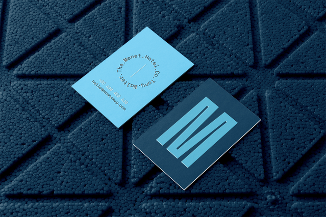 Two blue double-sided business cards on a dark textured surface — front side features a bold 'M' initial logo, reverse displays name and contact details. This double-sided business card print uses a monochromatic blue palette for a sleek, professional look — ideal for businesses and professionals seeking double-sided cards that maximise space for branding, contact info and creative design on both…